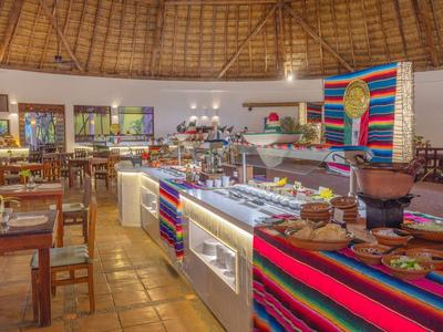 Hell beleuchteter Restaurantinnenraum mit Buffet und farbenfrohen dekorativen Stoffen.