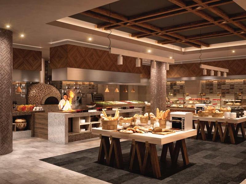 Moderner Selbstbedienungsbereich mit Holzdecken, beleuchteten Säulen, Tischen und vielfältigem Buffet.