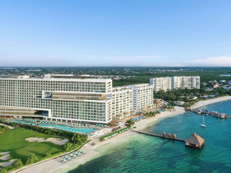 Grand complexe hôtelier en bord de mer avec des jetées et des parcours de golf à proximité.