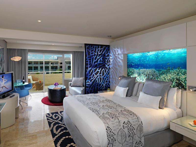 Camera d'hotel moderna con letto grande, decorazioni marine e vista sul mare.