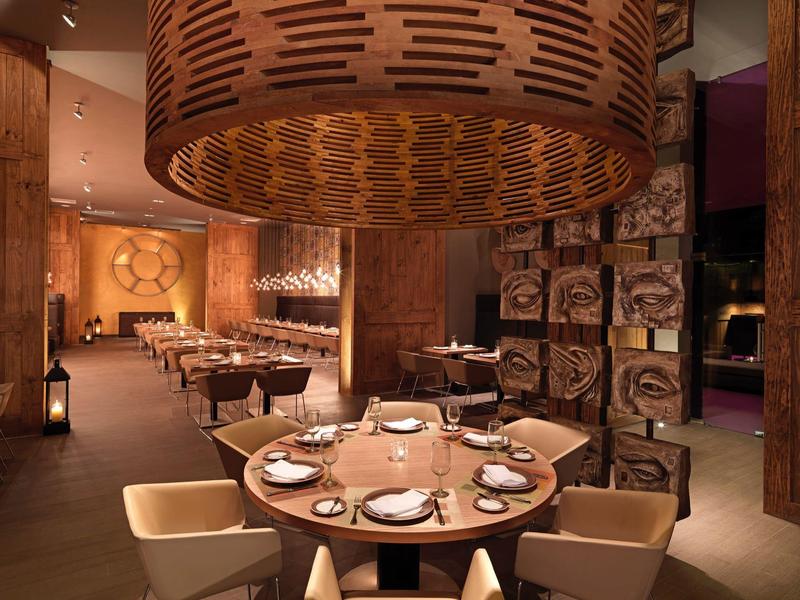 Interno accogliente di un ristorante con tavolo rotondo elegantemente apparecchiato.