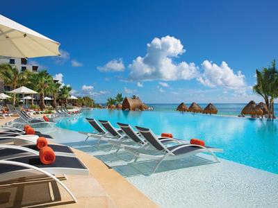 Infinity pool with loungers and umbrellas at a tropical resort