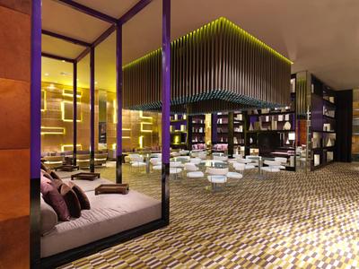 Moderní hotelová lounge s pohodlným sezením a stylovým osvětlením.