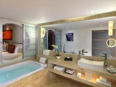 Bagno moderno con vasca idromassaggio, grandi specchi e illuminazione elegante.