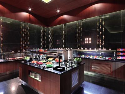 Elegantní bufetová oblast s výběrem jídla a nápojů v moderní hotelové restauraci.