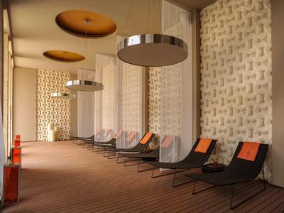 Area interna con moderni lettini e illuminazione decorativa in un hotel.