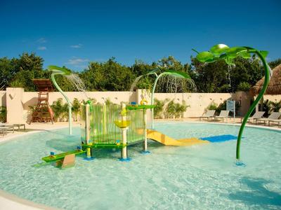 Parco giochi acquatico colorato in piscina poco profonda sotto il cielo blu in un resort vacanze.