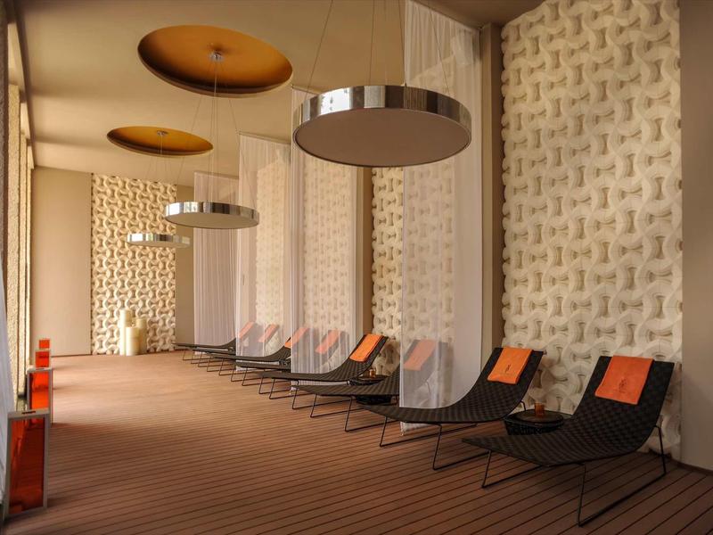 Area interna con moderni lettini e illuminazione decorativa in un hotel.