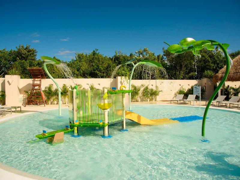 Parco giochi acquatico colorato in piscina poco profonda sotto il cielo blu in un resort vacanze.