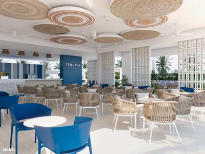 Heller, moderner Speisesaal mit weißen Möbeln, blauen Sesseln und dekorativer Decke in einem Hotel.