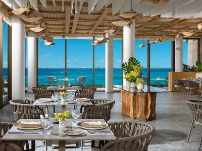 Area ristorante moderna con vista sul mare ed elementi di design marittimo.