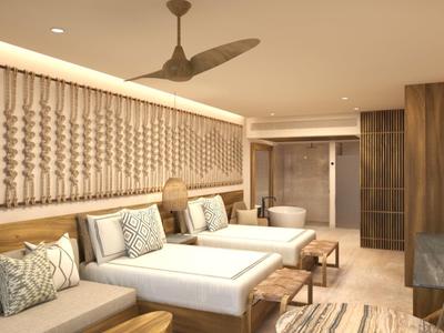 Modern hotelkamer met twee tweepersoonsbedden, grijze bank en houten inrichting.