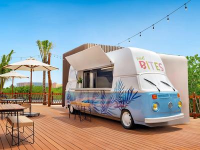 Camion-restaurant moderne au design coloré sur une terrasse en bois par temps ensoleillé