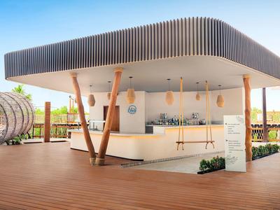 Bar extérieure moderne avec terrasse en bois et toit dans un cadre ouvert.