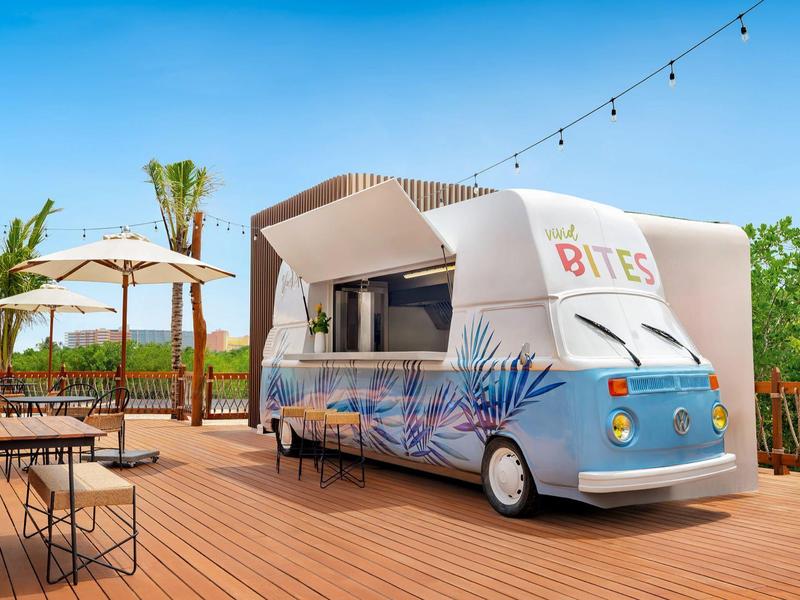 Camion-restaurant moderne au design coloré sur une terrasse en bois par temps ensoleillé