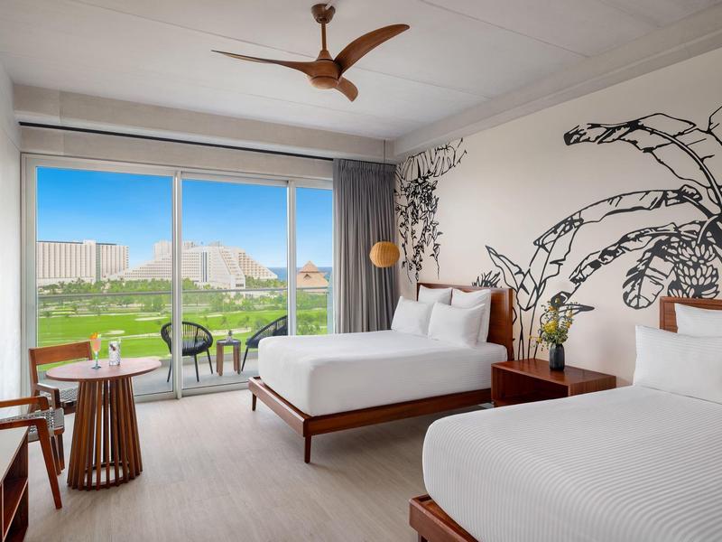 Chambre d'hôtel lumineuse avec deux lits, décoration moderne et vue sur un paysage verdoyant.