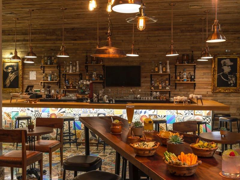 Bar accogliente in legno con sgabelli e buffet di snack invitanti.