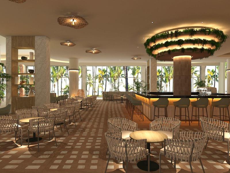 Nowoczesny bar z okrągłymi stołami, krzesłami z drutu i oświetlonym żyrandolem.