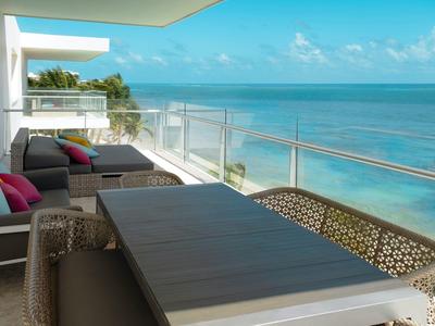 Terrazza con zona pranzo e mobili lounge con vista sul mare in una giornata di sole.