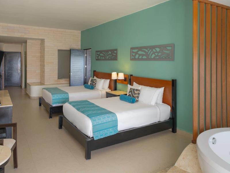 Camera d'hotel moderna con due letti queen size e vasca da bagno