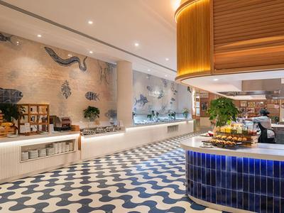 Modern hotel buffet area with blue and white tiles and wood paneling.