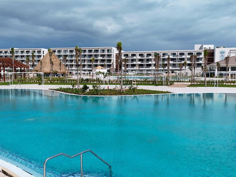 Grande resort con una vasta piscina e un edificio alberghiero su più piani sullo sfondo.