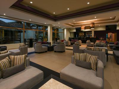 Lounge moderna dell'hotel con poltrone comode e illuminazione calda, vista sull'area esterna.