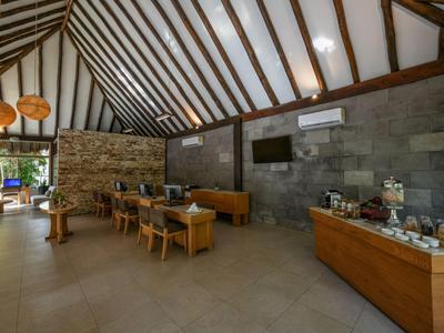 Modernes Hotellobby mit Holz- und Steindekor, Sitzbereichen und Buffet.