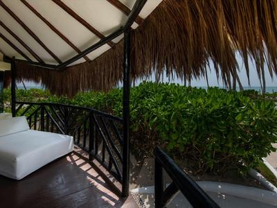 Accogliente area lounge sotto un tetto di paglia con vista sulla spiaggia e sul mare.