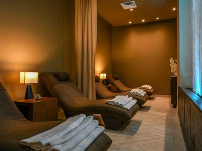 Lounge spa con luci soffuse, poltrone reclinabili e asciugamani.