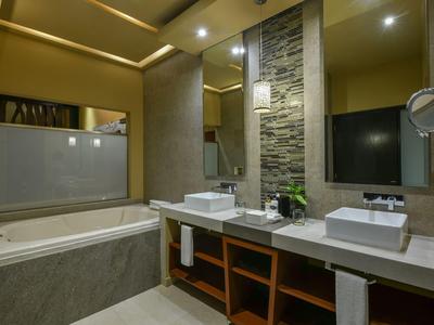 Bagno moderno con due lavandini, vasca da bagno grande e specchio illuminato.