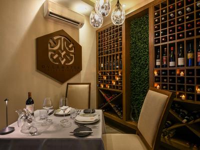 Elegancki pokój na wino z regałami na wino, stołem dla dwóch osób i nowoczesnym oświetleniem.