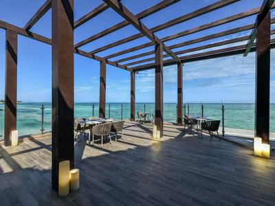 Otevřená terasa s dřevěnou konstrukcí a výhledem na moře pod jasnou oblohou