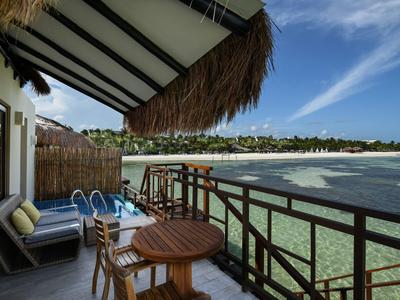 Balkon s útulnou relaxační zónou a malým bazénem s výhledem na pláž a moře.