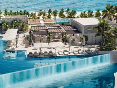 Luxuriöses Resort mit Infinity-Pool, Sonnenliegen, Palmen und Blick auf den Ozean.