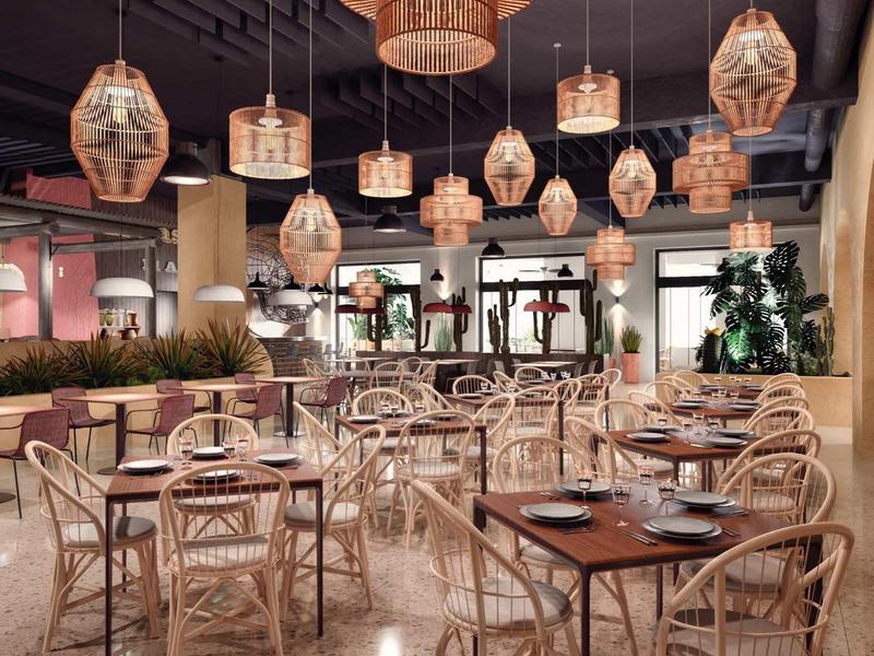 Pohodlná hotelová jídelna s dřevěnými stoly a kulatými ratanovými světly.