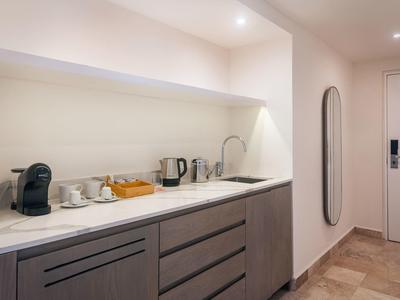 Angolo cottura moderno con macchina per caffè, bollitore e microonde in camera d'hotel