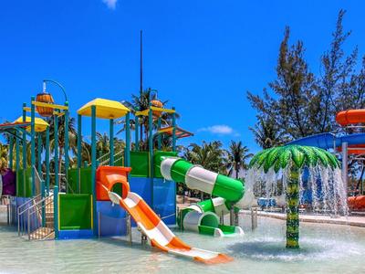 Parco acquatico colorato con scivoli e giochi d'acqua sotto un cielo azzurro.