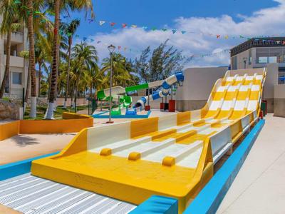 Scivolo d'acqua giallo e bianco in un'area piscina dell'hotel sotto un cielo azzurro.