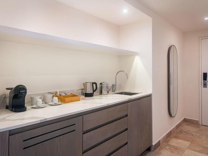 Angolo cottura moderno con macchina per caffè, bollitore e microonde in camera d'hotel