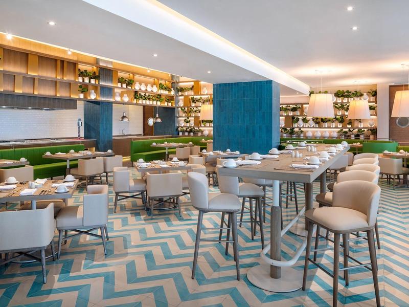 Ristorante moderno con sedie comode, soffitto alto e illuminazione elegante.