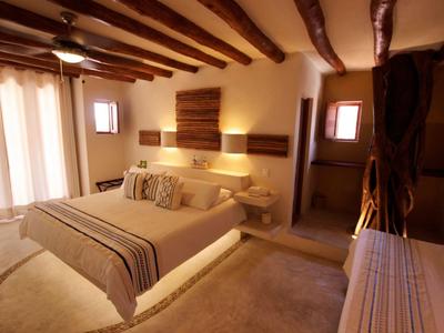 Gemütliches Schlafzimmer mit Doppelbett, Holzbalken und warmem Licht.