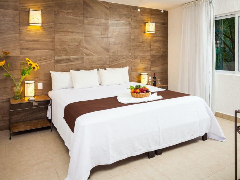 Camera d'hotel moderna con grande letto, parete in legno e finestra con tende.