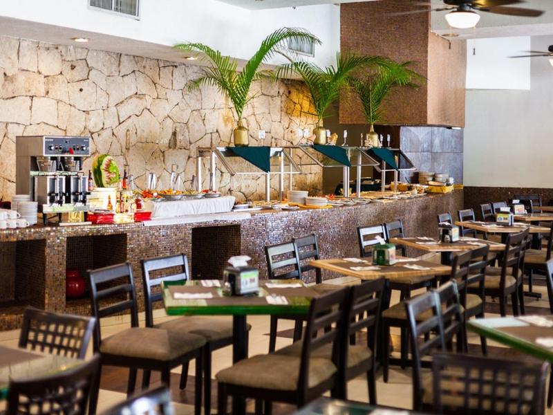 Ristorante dell'hotel moderno con parete in pietra, piante verdi e area buffet.