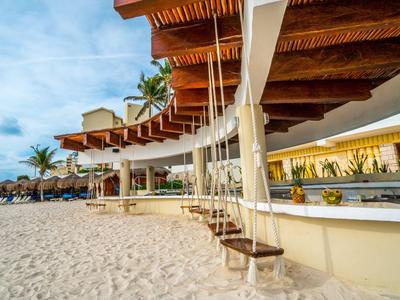 Schaukel mit Blick auf den Strand und Sonnenschirme unter einem Holzdach.
