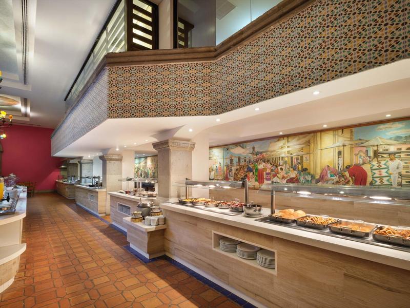 Espace buffet moderne avec comptoir éclairé et plats variés dans un hôtel.