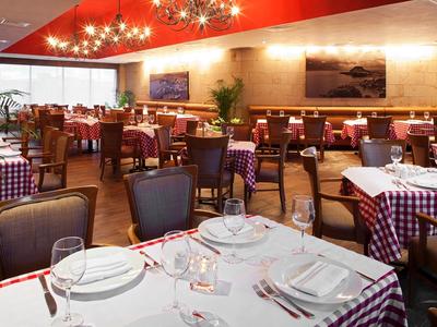 Restaurante con manteles a cuadros rojos y blancos y mesas preparadas en un ambiente elegante.