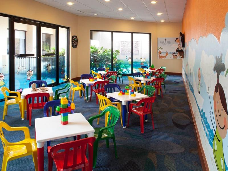 Kolorowy kącik zabaw dla dzieci z stolikami i krzesłami w kawiarni lub restauracji hotelowej.