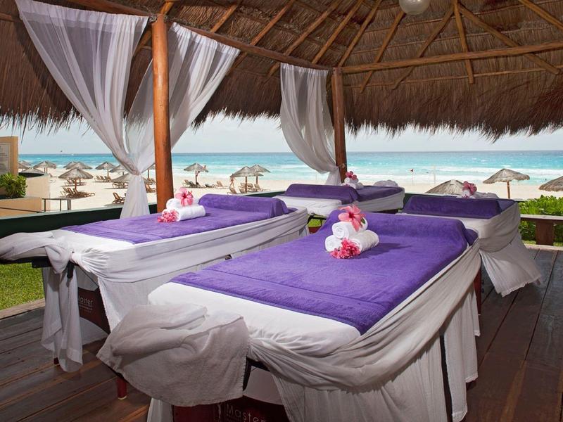 Otwarta chata do masażu z dwoma łóżkami z widokiem na plażę i morze.