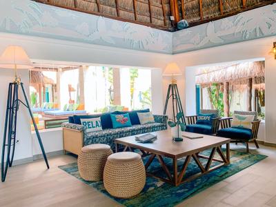 Soggiorno luminoso con divani comodi, lampade da terra e ampie finestre con vista esterna.